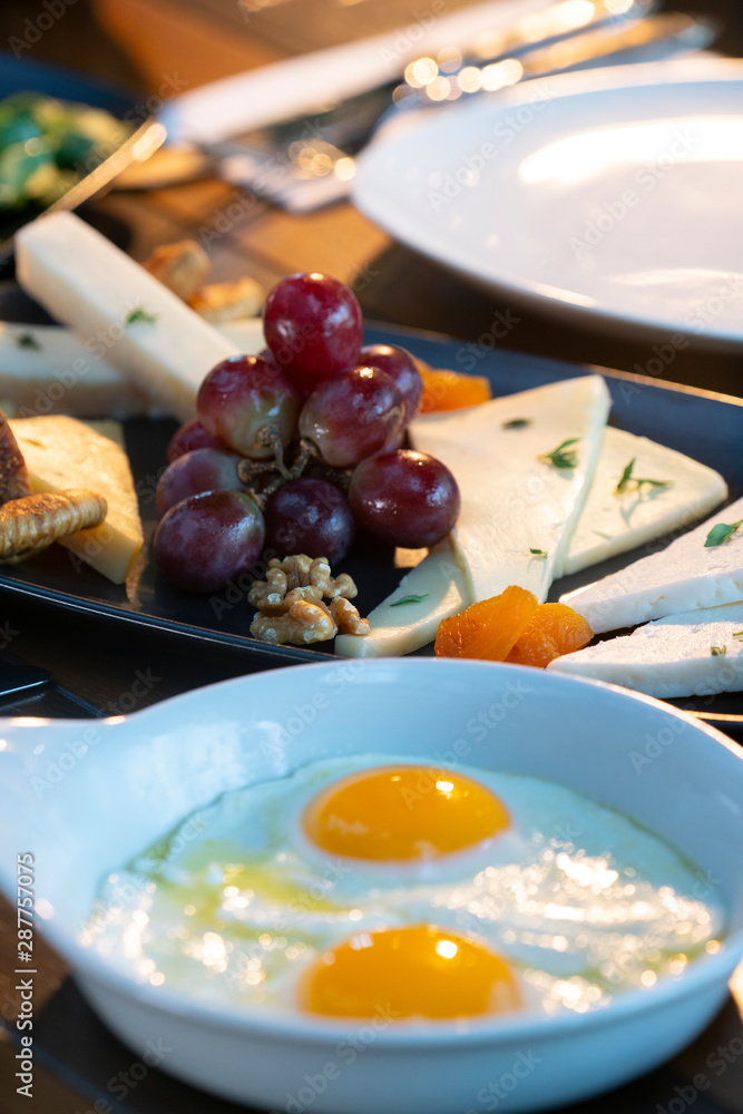Breakfast with fried egg and cheese plate on wooden table
