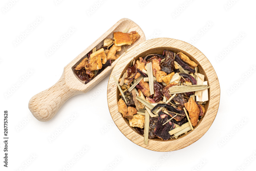 Closeup of lot of pieces of lingonberry strawberry fruit tea in wooden bowl with wooden scoop flatlay isolated on white background