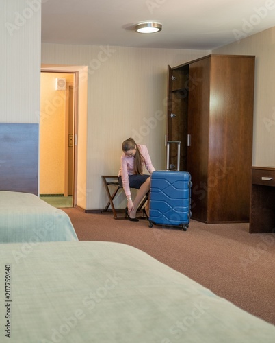 Foto Beautiful woman takes off her shoes in hotel room