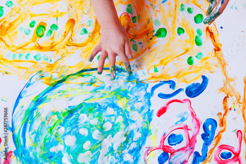 Child girl painting with colorful hands and finger. Happy childhood, art, drawing concept.