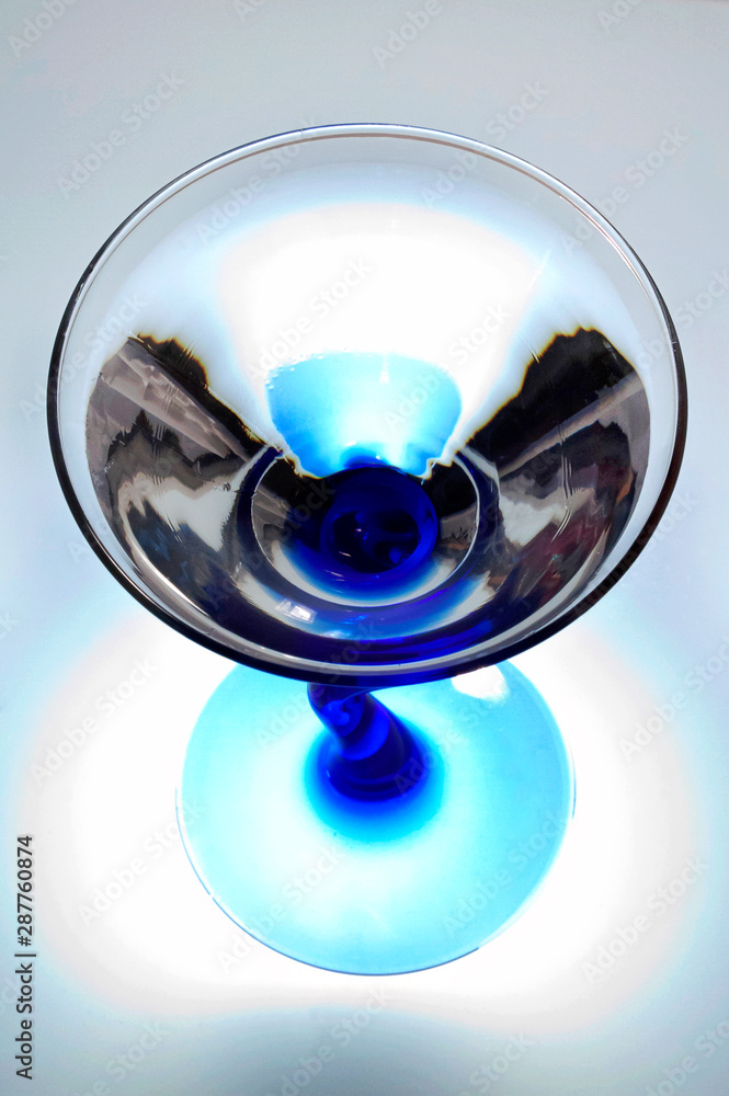 Blue and clear cocktail glass from above with white background