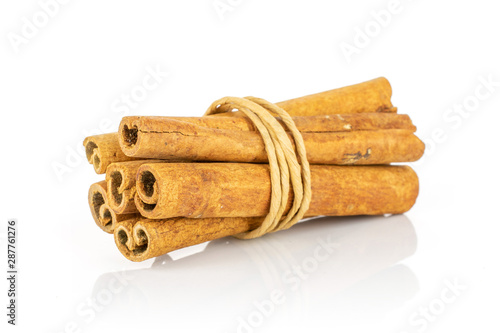 Group of six whole dry brown cinnamon wrapped in natural twine isolated on white background
