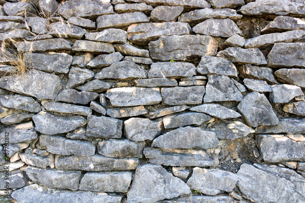 wall of old stones overgrown with grass, close-up