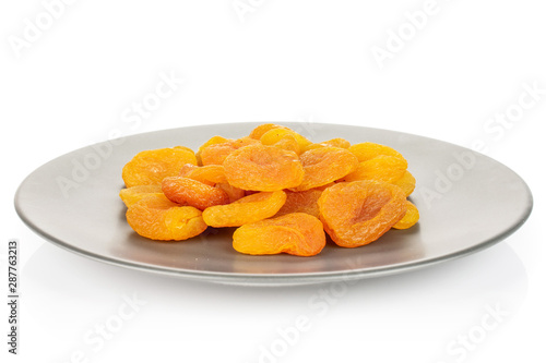Lot of whole dried orange apricot on gray ceramic plate isolated on white background