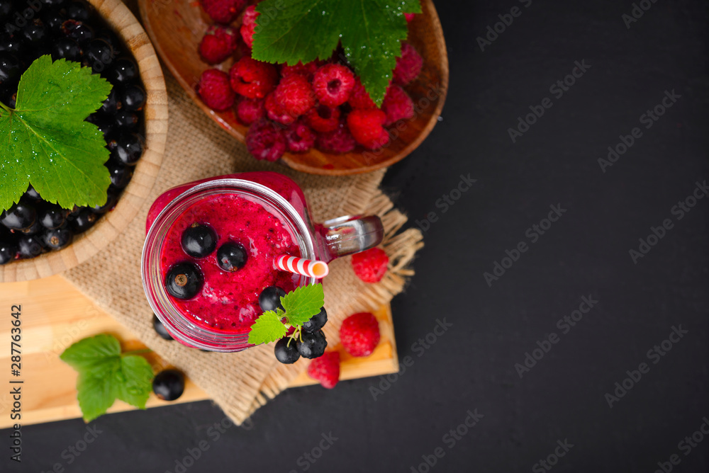 Raspberry and currant berry smoothie in a glass jar with a straw and mint leaf Raspberry and currant berry smoothie in a glass jar with a straw and mint leaf