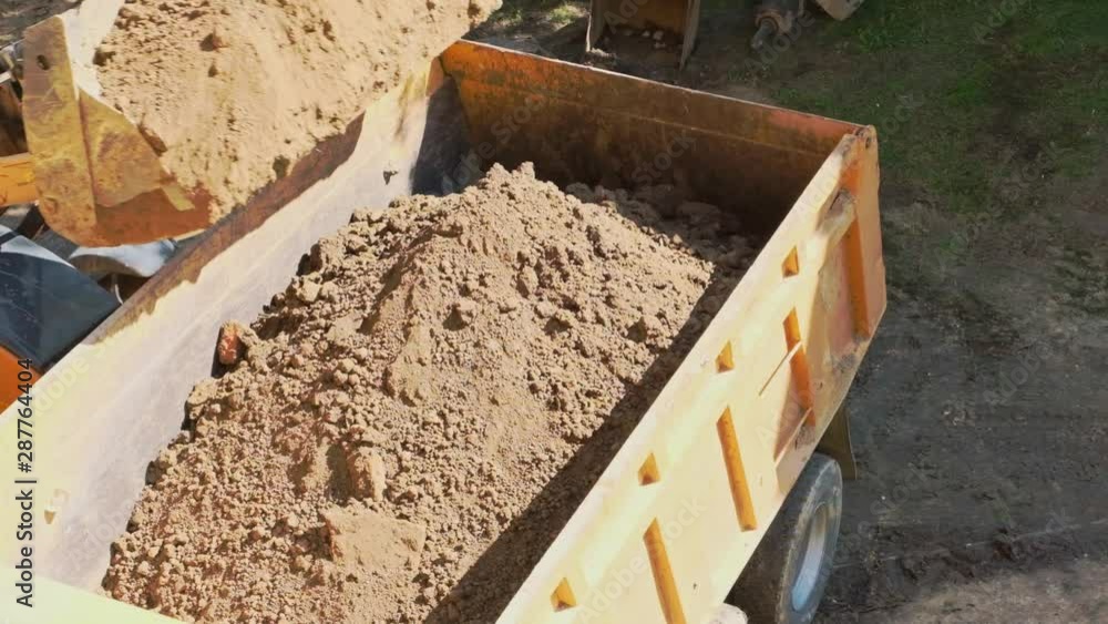 Excavator, digger loading soil into dumper truck. Slow motion video. Excavator, digger loading soil into dumper truck. Slow motion video.