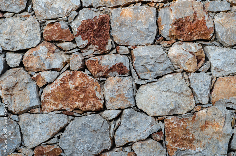 Fototapeta premium Modern wall of large unprocessed pieces of rock, stones. Background stone wall.