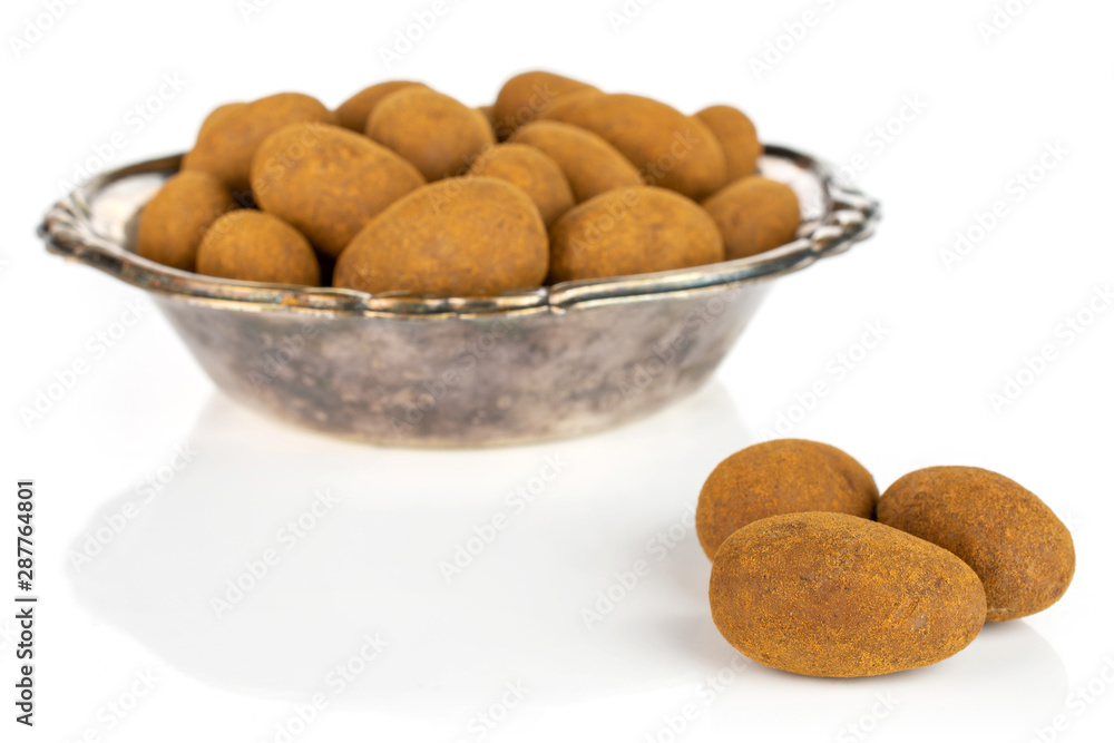 Lot of whole sweet brown chocolate cinnamon almond in metal bowl isolated on white background Lot of whole sweet brown chocolate cinnamon almond in metal bowl isolated on white background