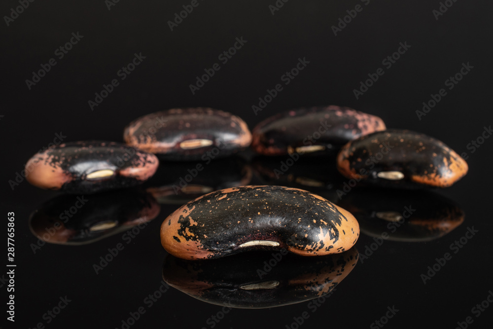 Group of five whole stained purple bean isolated on black glass Group of five whole stained purple bean isolated on black glass
