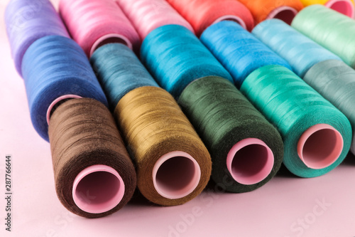 Accessories for sewing and needlework. Many multi-colored spools of thread. Bobbins with colored thread
