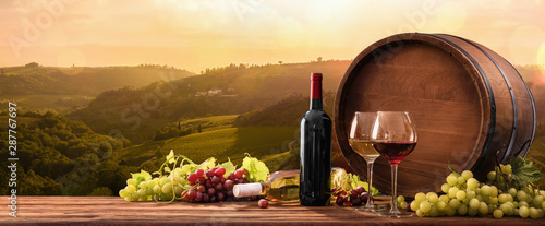 Fototapeta Naklejka Na Ścianę i Meble -   Wineglasses With Grapes And Barrel On A Sunny Background