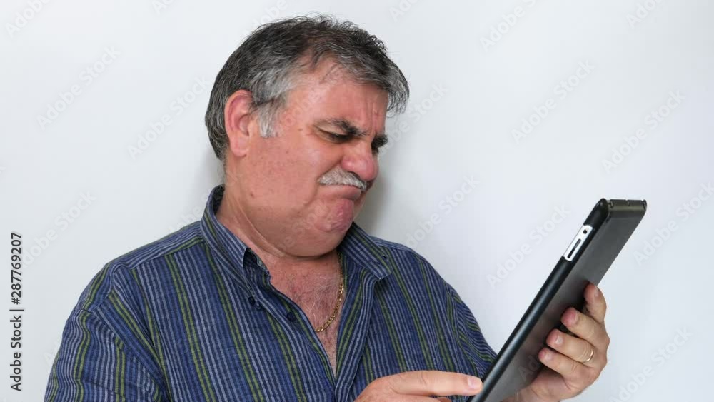 Senior man reacting to loss and using tablet isolated on white background. Shot in 4K Senior man reacting to loss and using tablet isolated on white background. Shot in 4K