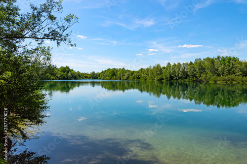 Forest lake in German national park with clear blue sky reflection