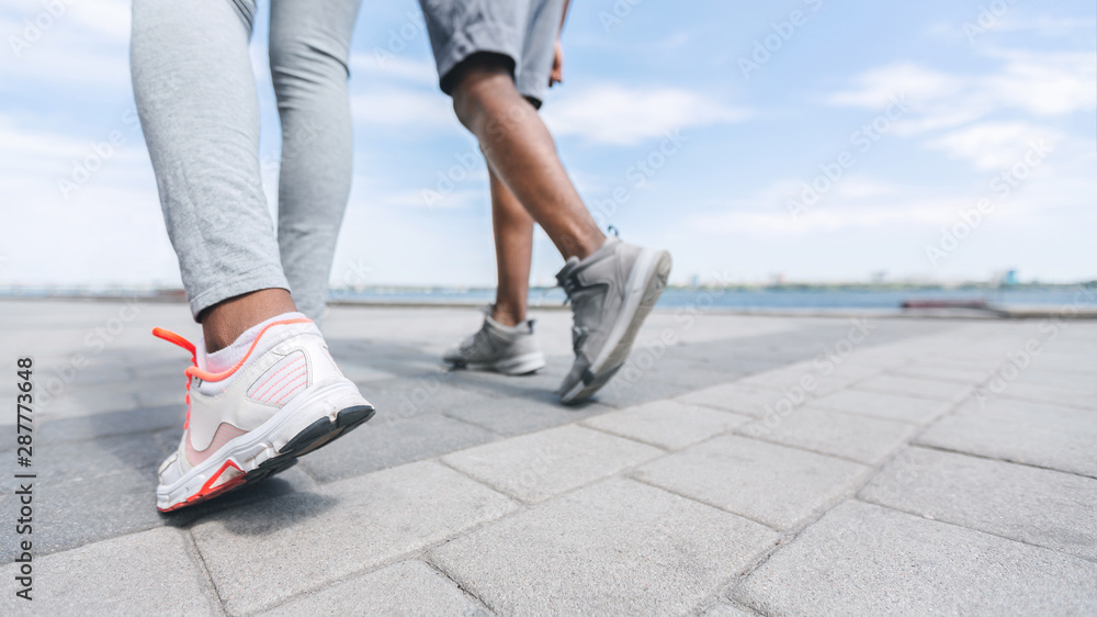 Unrecognizable Afro Couple Legs Running Along River Embankment, Crop Unrecognizable Afro Couple Legs Running Along River Embankment, Crop