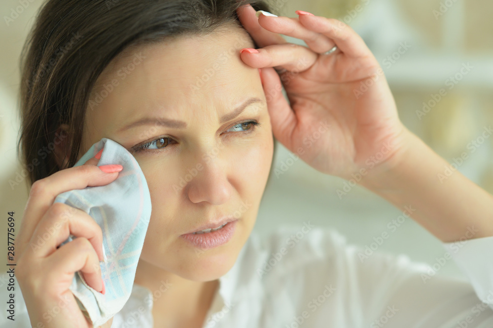 Beautiful young crying woman posing at home