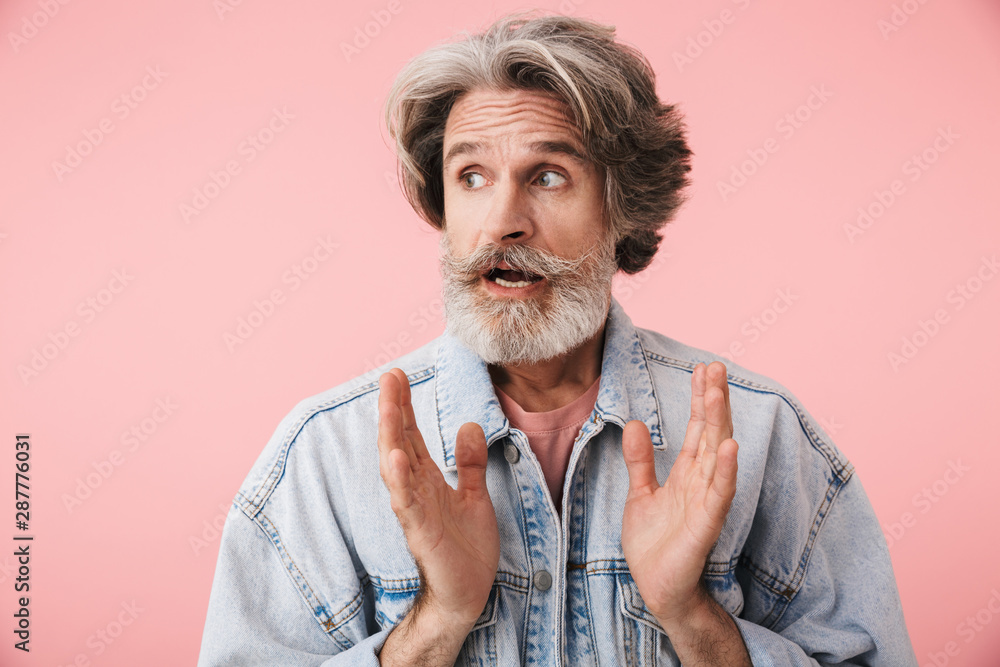 Portrait of astonished old man with gray beard looking aside at copyspace with throwing up hands Portrait of astonished old man with gray beard looking aside at copyspace with throwing up hands