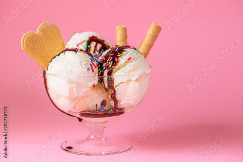 Принти на полотні scoops of ice cream in glass bowl with chocolate sauce, strewed sprinkles and co