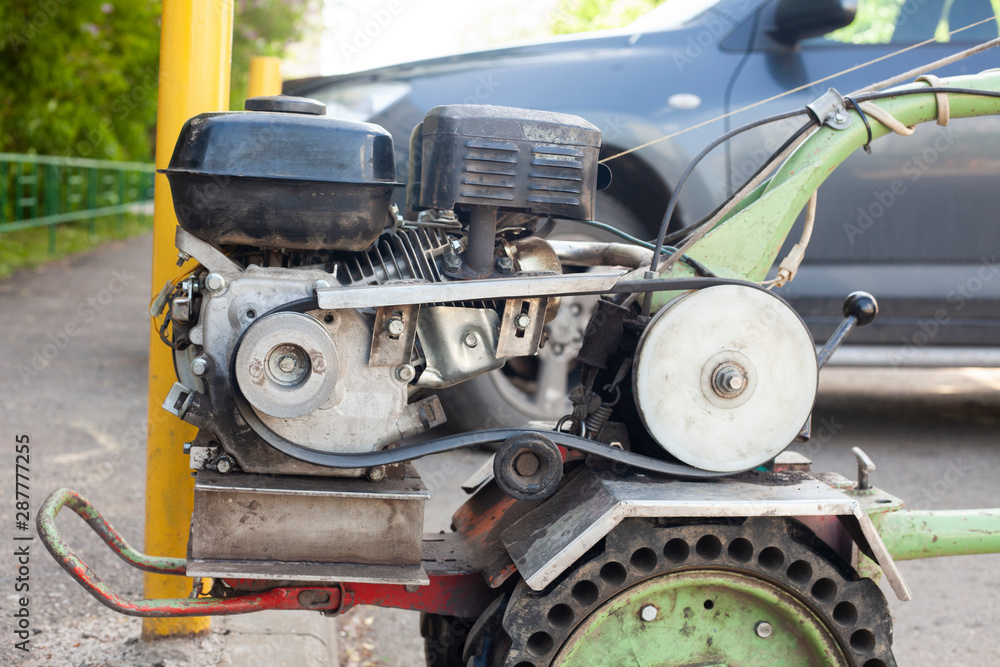 Moto block. Wheeled engine for plowing the land. A simple cross country vehicle. The engine parts are visible from the outside. Moto block. Wheeled engine for plowing the land. A simple cross country vehicle. The engine parts are visible from the outside.