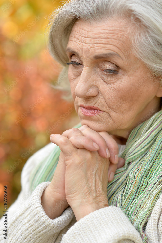 Portrait of a cute sad senior woman outdoors