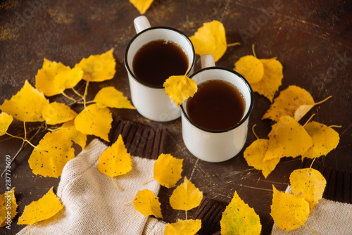 two white cups of tea in the yellow leaves, the concept of cosiness, warmth and autumnal sadness © malykalexa777