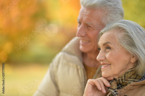 Happy senior couple in autumn park hugging