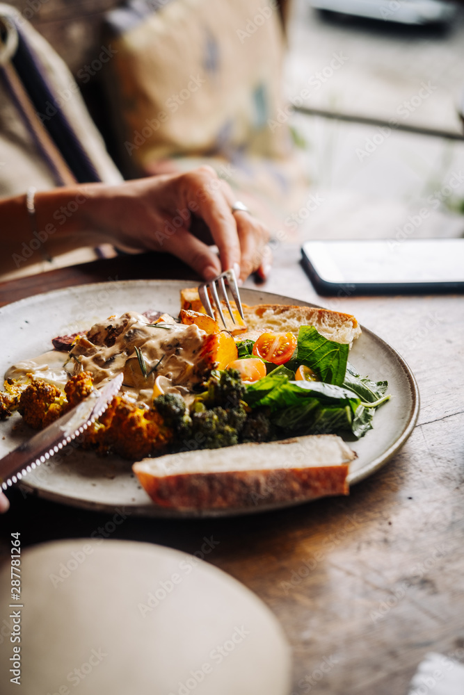 Woman having warm hearty breakfast, lunch with organic farm spicy curry veggies. Slow food living concept, close up, food photography