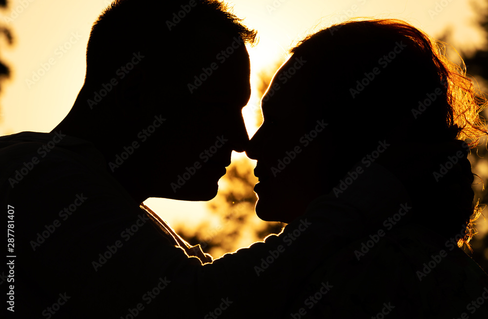Silhouette of a couple in love against the background of the setting sun