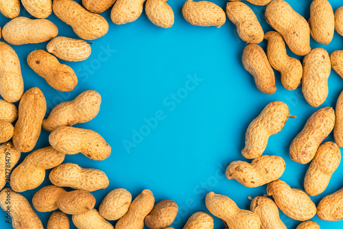 Inshell peanuts on a blue background, space for text