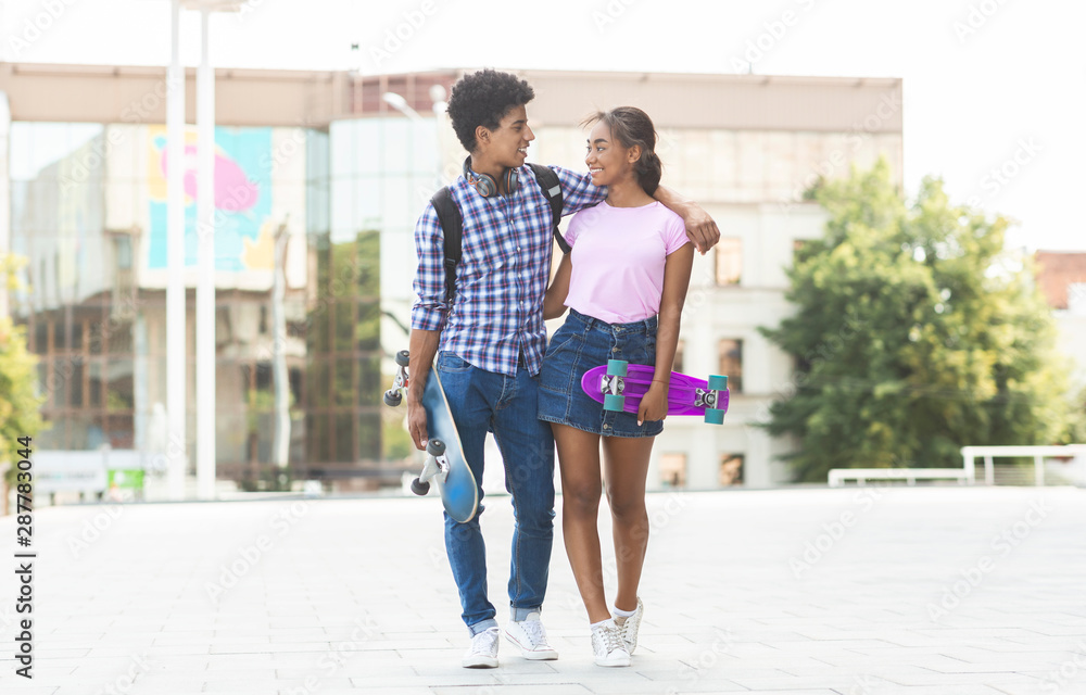 Teens dating in the city walking together outdoors