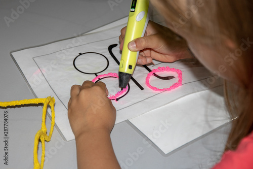 The girl draws with a 3D pen using ABS plastic.