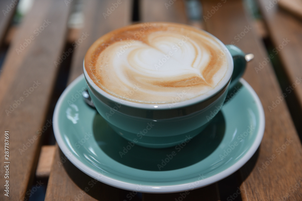 A cup of cappuccino coffee with latte art.Beautiful foam, vintage ceramic cup. A cup of cappuccino coffee with latte art.Beautiful foam, vintage ceramic cup.