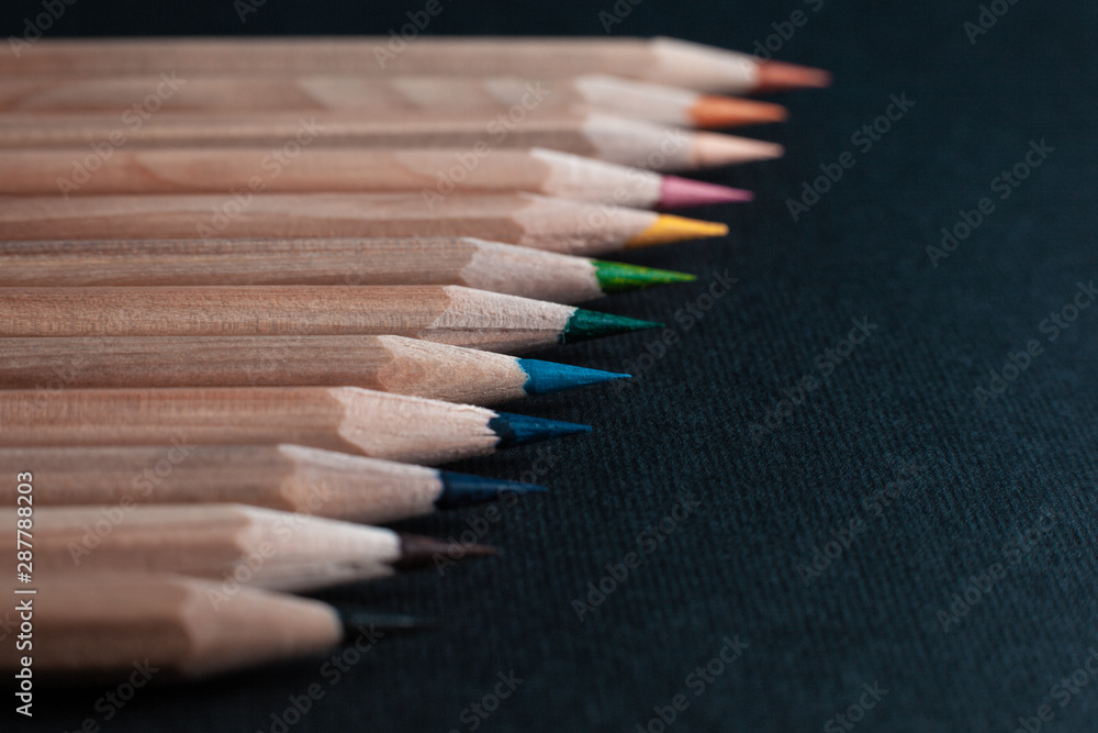 Sharpened pencils of different colors made of light wood isolated on black background. Sharpened pencils of different colors made of light wood isolated on black background.