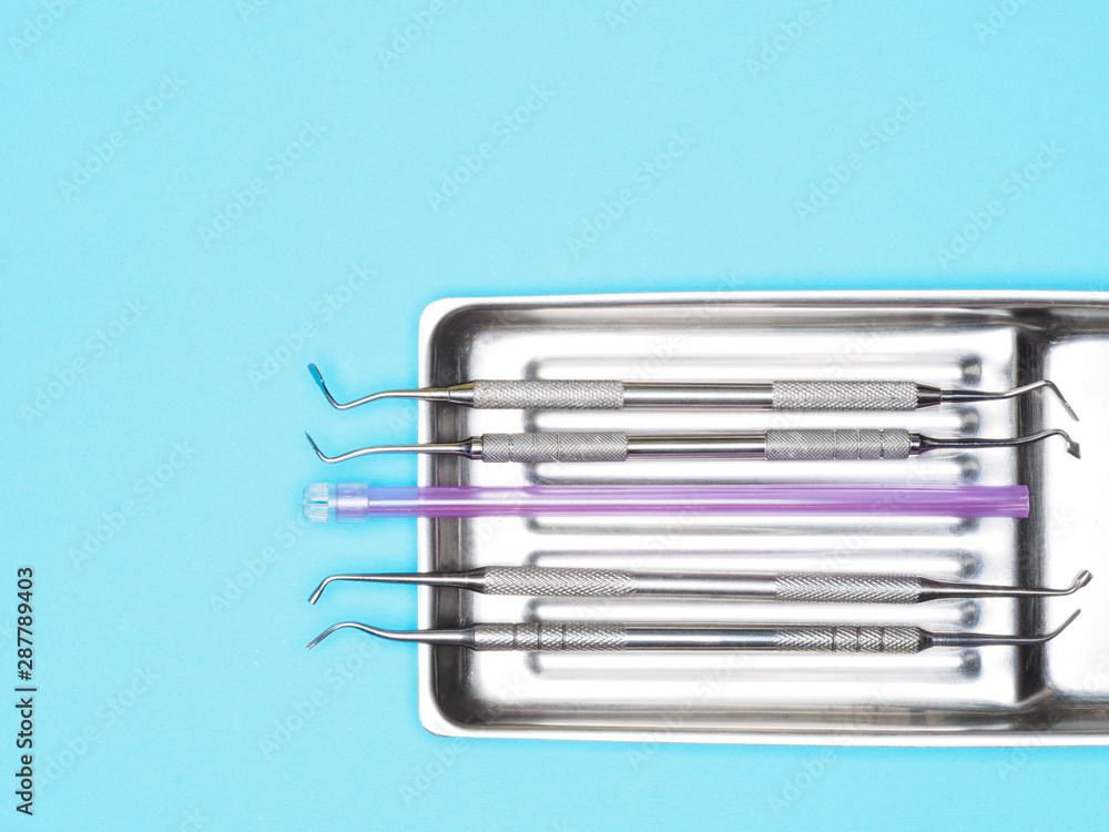 Dental instrument in tray on blue background with copy space. Dental care concept Dental instrument in tray on blue background with copy space. Dental care concept
