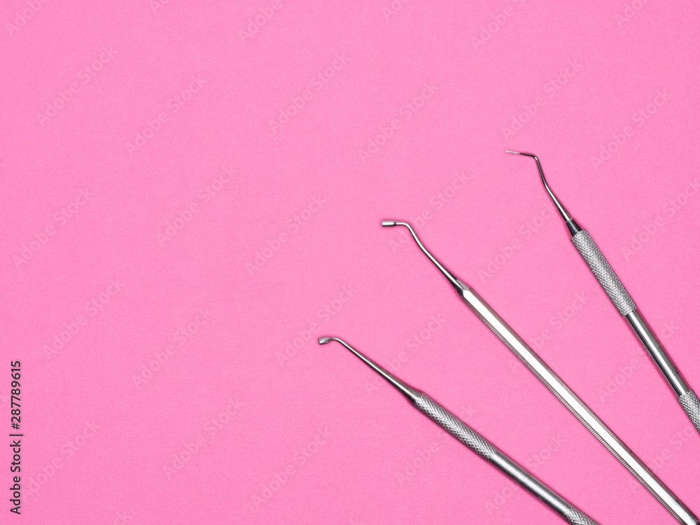 Dental instrument on pink background with copy space. Dental care concept Dental instrument on pink background with copy space. Dental care concept