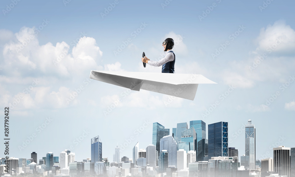 Aviator driving paper plane above business center Aviator driving paper plane above business center