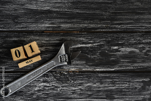 May 1 text wooden block calendar and adjustable wrench on black wooden background for Worker day, Labor day, labour day.