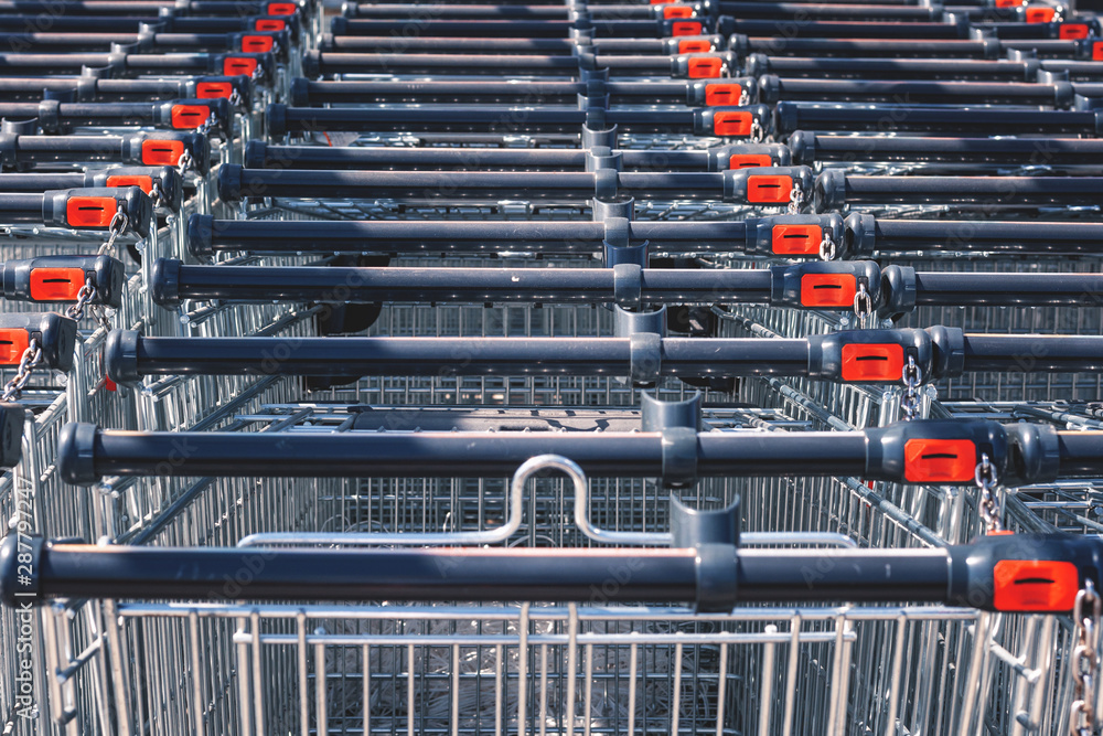 Shopping carts in the store, assembled in a row in the parking lot. Close-up. Shopping carts in the store, assembled in a row in the parking lot. Close-up.