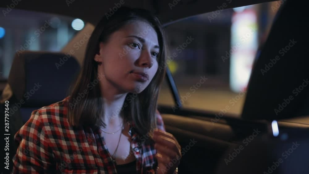 Woman preens in a car sitting on passenger seat at night looking at mirror Woman preens in a car sitting on passenger seat at night looking at mirror