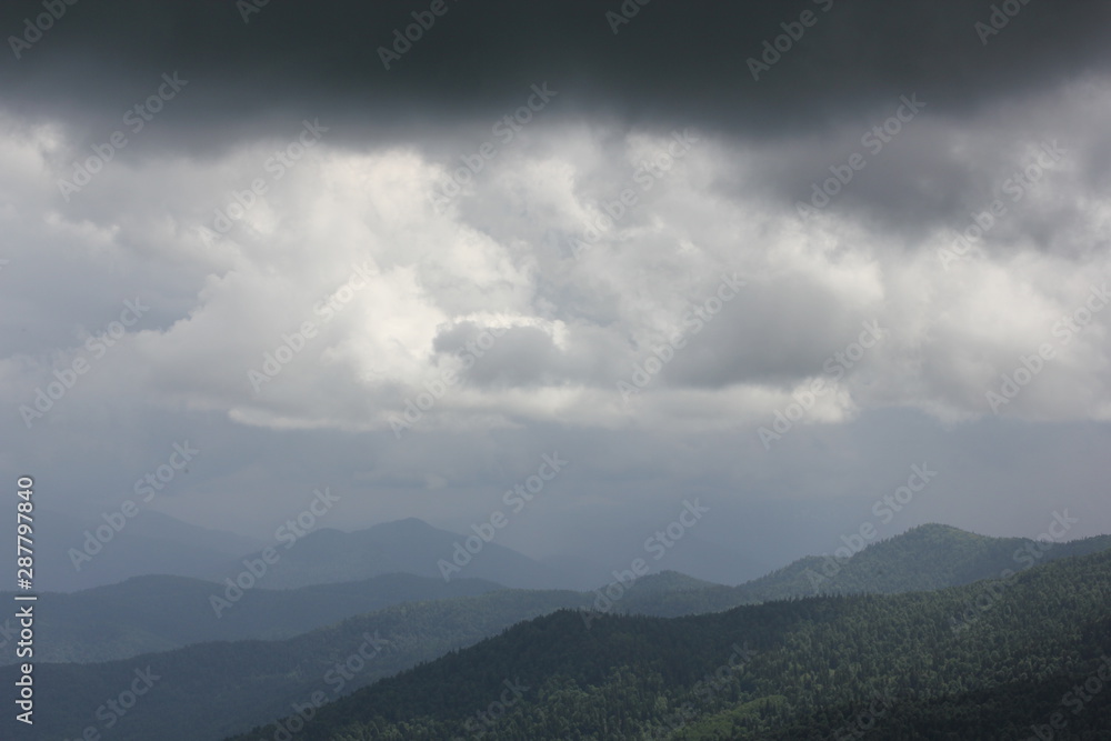 panoramic view of green mountains and gray sky with clouds