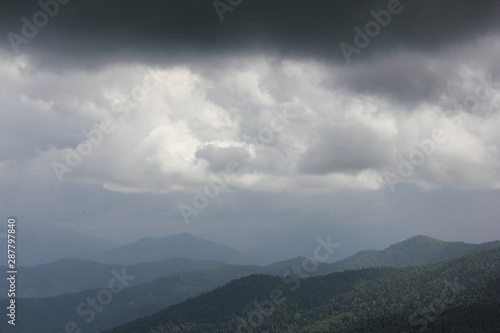 panoramic view of green mountains and gray sky with clouds