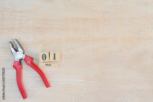 Top view of handy tools with May 1 text wooden block calendar on light wooden board background with copy space for your text for Worker day, Labor day, labour day.