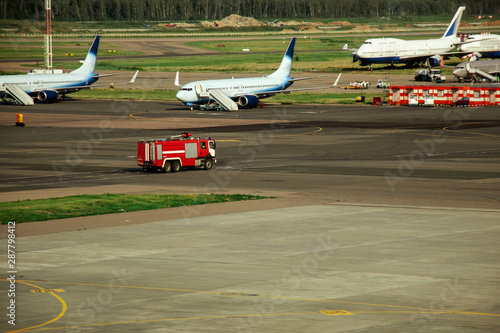Fire truck on the runway near the aircraft. Airport Rescue Service. Firefighters and fire department at the airport. Crisis Response System.
