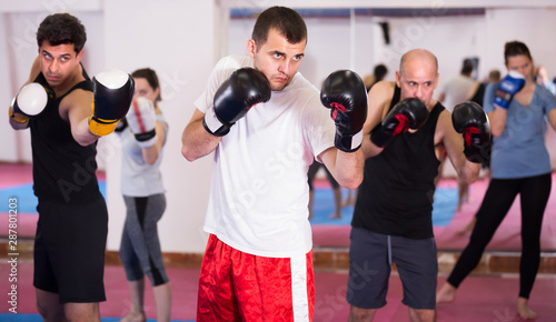 Cheerful sportsmen practicing boxing punches