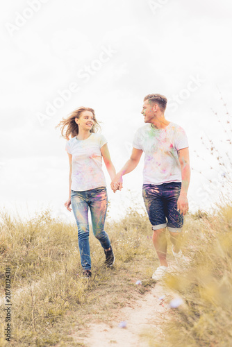 attractive woman and handsome man smiling and holding hands