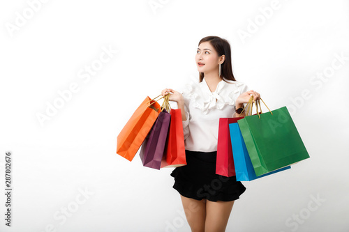 Portrait of an excited beautiful woman holding shopping bags isolated on white.