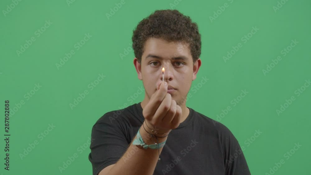 Young Boy Lighting A Match And Showing It To The Viewer