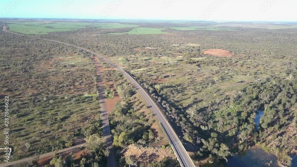 Flight above Murchison River towards Kalbarri National Park, with aerial panorama of outback agricultural country, highway bridge, blue sky and horizon on a summer sunny day. Flight above Murchison River towards Kalbarri National Park, with aerial panorama of outback agricultural country, highway bridge, blue sky and horizon on a summer sunny day.