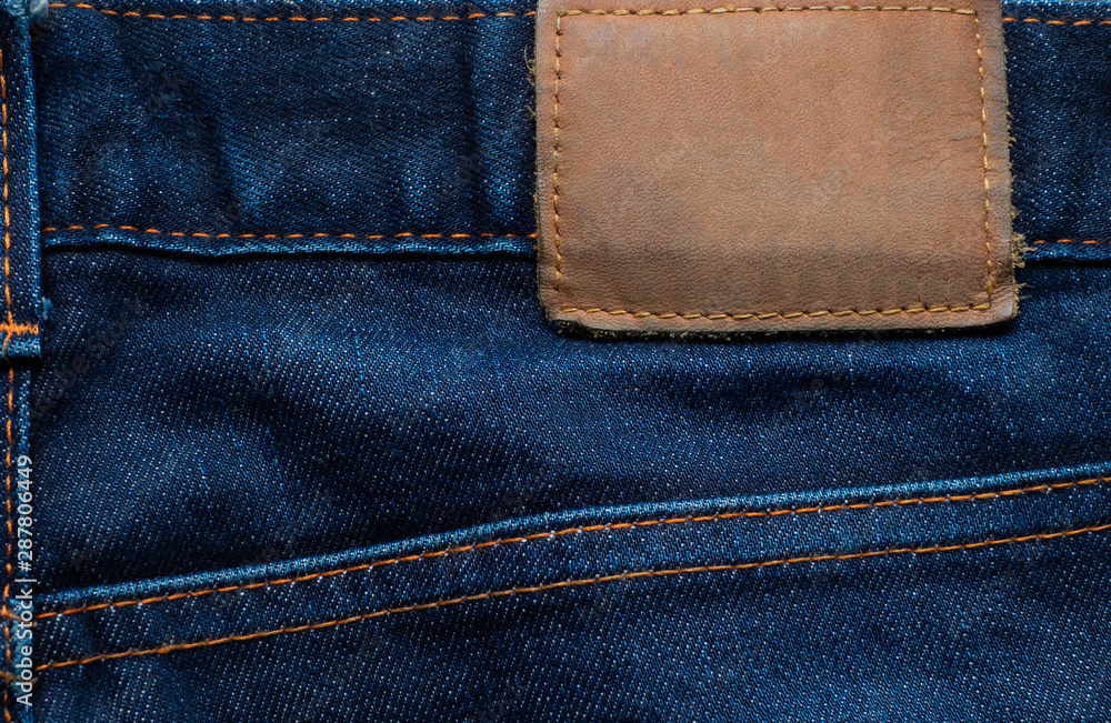 Macro, Close-up of blank leather label on new denim blue jeans trousers. fashion and retro stlye on background.
