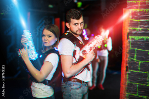 Man and woman back to back in laser beams