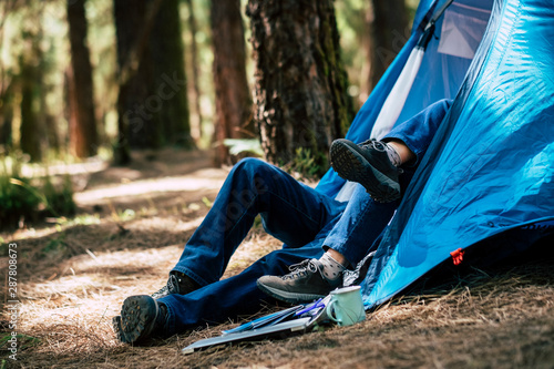 Unrecognizable couple in outdoor leisure  activity inside a tent in the forest- concept of alternative travel and enjoy nature lifestyle together withlove and relationship photo